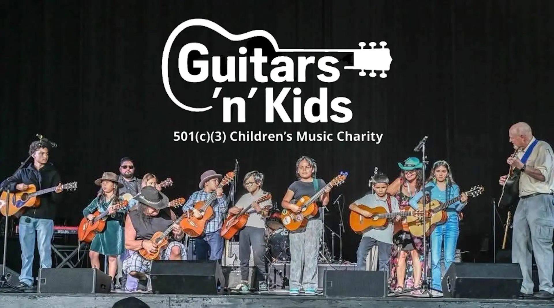 Guitars 'n' Kids students and founder Barbara Gorin performing with their guitars